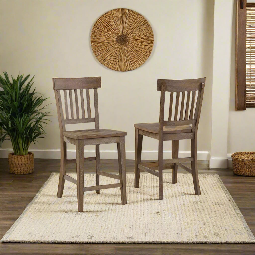 Two wooden bar stools in a room with a window and plants.