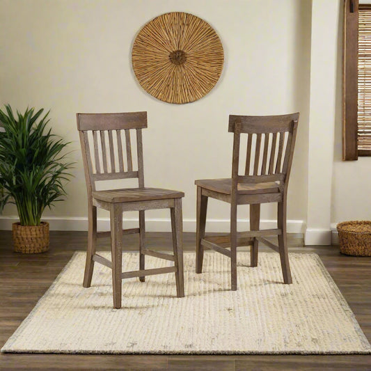 Two wooden bar stools in a room with a window and plants.